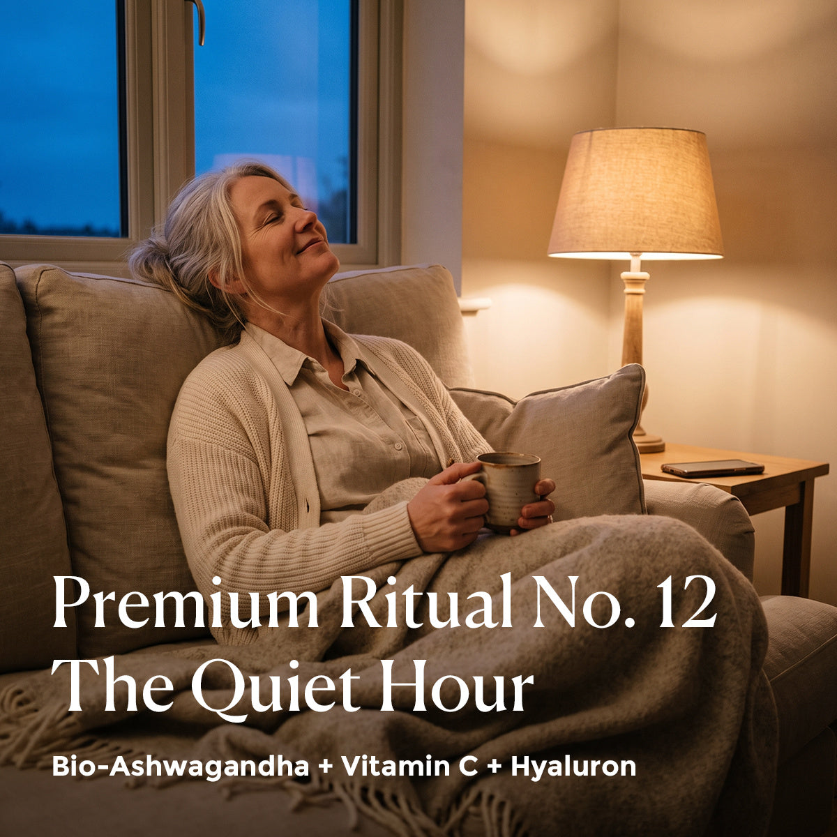 Premium Ritual No. 12 The Quiet Hour mit Bio-Ashwagandha: Frau mit Tee und Wolldecke abends auf dem Sofa [KI]